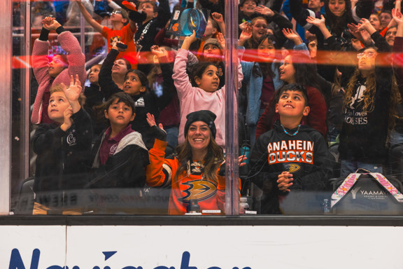 Students and teachers smiling and cheering from their seats on the glass