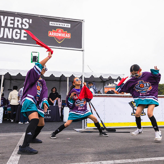 A few young girls dance in their street hockey jerseys with free swag