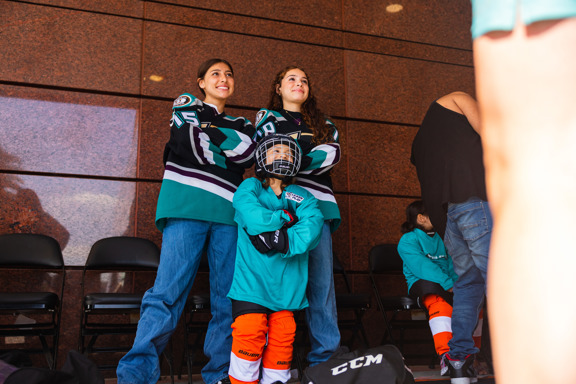 Anaheim Lady Ducks players posing with new Learn Her Way participant. 