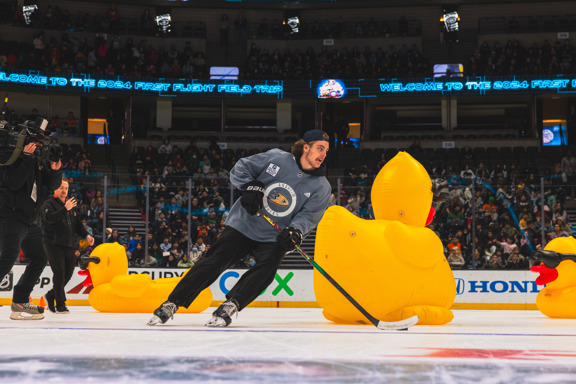 Anaheim Ducks player skating around giant inflatable ducks